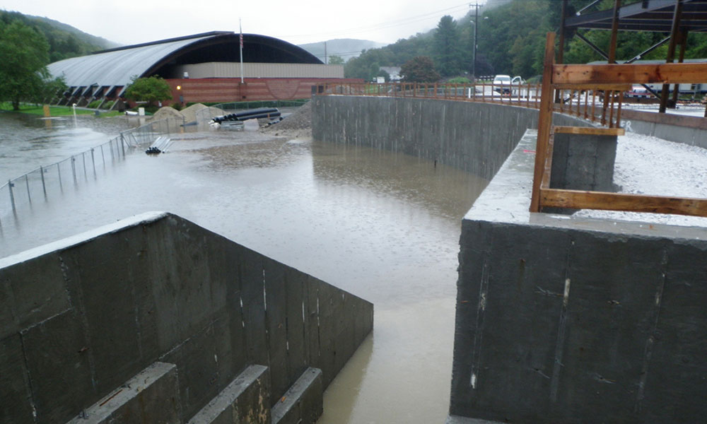 <p>The integrated design-build team collaborated to resolve flooding and poor soil-bearing capacity by designing a structural stone retaining wall 300 ft long, ten foot high, to act as a flood wall during and after construction. </p>
