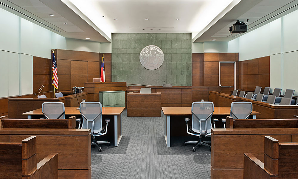 <p>Matching slate from the outside of the building carries through the courtroom vestibules and into the focal wall of each courtroom. The combination of warm and rich materials with the open rail between spectator seating and the well breaks down the traditional hierarchy and encourages civil behavior in the courtroom.</p>
