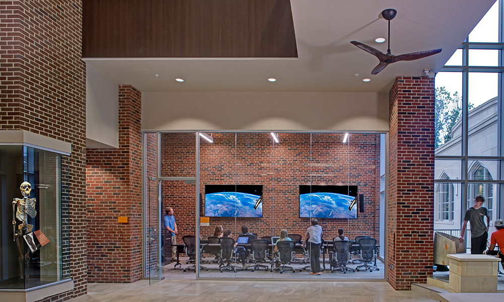 <p>Located along the atrium, the Visualization Lab is housed inside a remnant of the existing 1925 dorm, creating a dynamic juxtaposition of old and new. Just outside the lab, an anthropology display is housed in the original chimney.</p>
