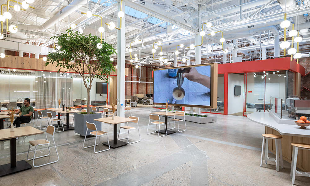 <p>Creating new avenues for in-house operations, the office café is bordered by generous meeting rooms, the café bar and tasting room, and a sizable screen that pilots the company’s digital media.</p>
