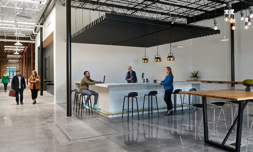 <p>A bar equipped with taps, sinks, and plentiful seating invites building tenants to connect with one another and serves as an alternative work setting, depending on end-user preferences.</p>

