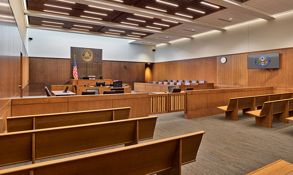<p>Clerestory windows over the judge’s bench bring natural light into the courtroom, representing the idea of transparency in the judicial system. Oak panels, intricately carved wooden well gates inspired by the late artist and craftsman Lynn Ford, and the studded leather wall behind the judge’s bench create a unique and distinctly South Texas courtroom experience.</p>
