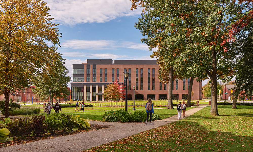 <p>The building has a rhythm of long narrow curtain wall slots and an open loggia on the first floor defining a new campus green creating a link back to the main campus. The design reflects the brick and arched loggias of the existing campus architecture.</p>
